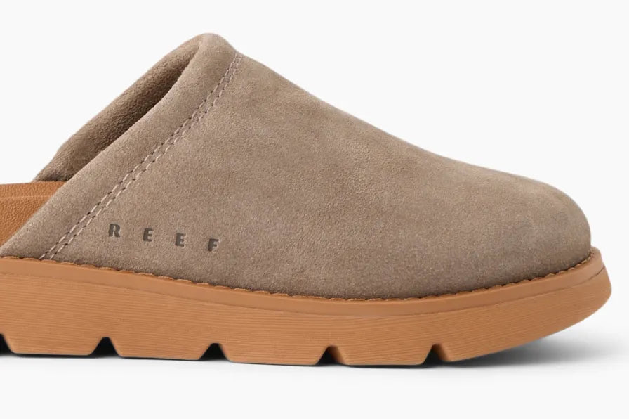 Side view of a tan suede clog facing right with cushioned sole and subtle REEF logo embossed near heel area