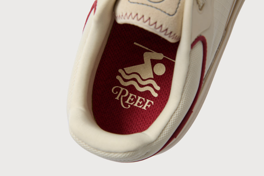 Close-up of a REEF shoe facing toward the bottom, showing its cushioned footbed and interior logo