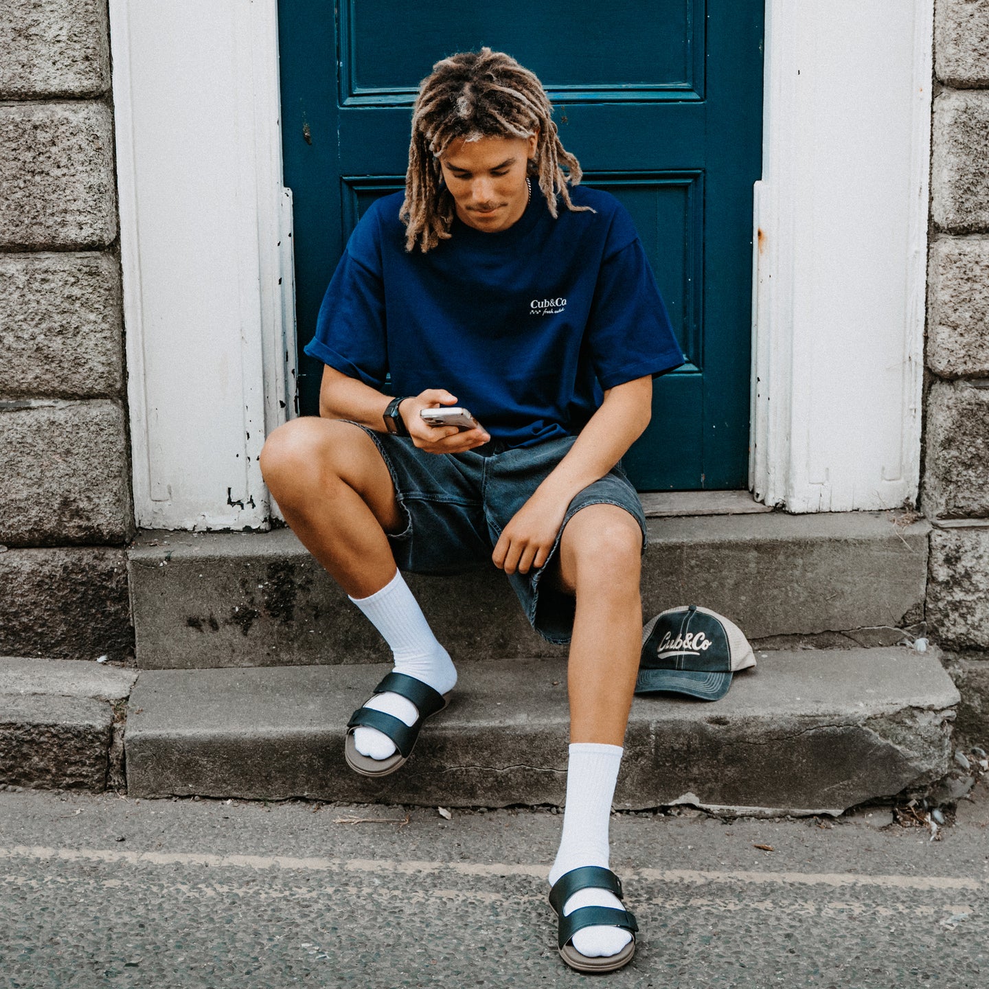 Phantom Tradewind black slides facing forward, featuring cushioned comfort for everyday wear by the beach
