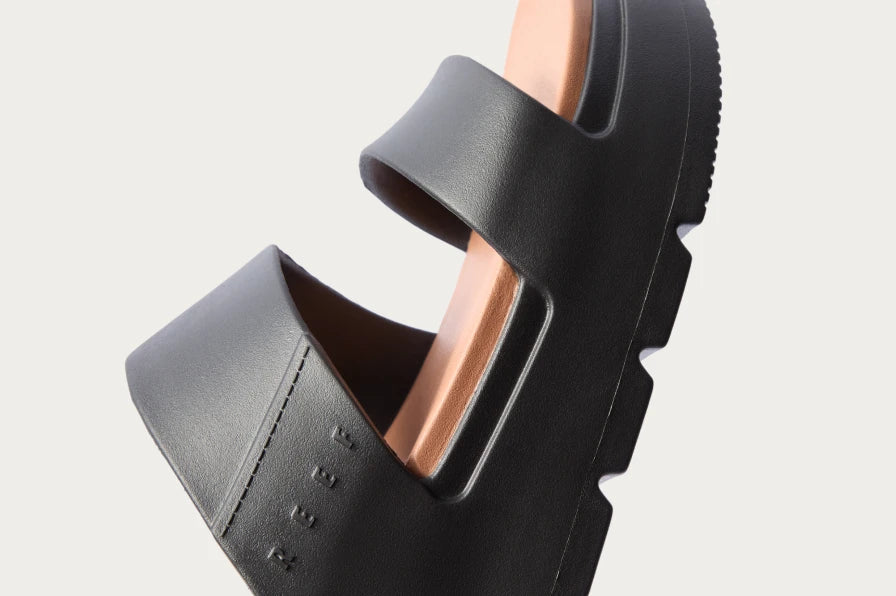 Close-up of black REEF sandal facing left with soft-rebound cushioning and sleek, water-friendly design for beach comfort.