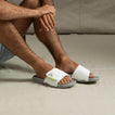 Man wearing Phantom Slab slides facing forward, showing soft white straps and cushioned arch support design.