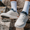 Shoreline Del Mar white sneakers one facing forward and one facing left on rocky terrain with cushioned comfort