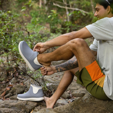 Man wearing grey Scallywag slip-on shoes facing left, showing side with lightweight, water-friendly design.
