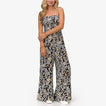 Woman wearing black floral Sandy Romper standing front view with relaxed fit and lightweight fabric, beach-inspired comfort.