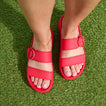 Vista Capri women's red sandals seen from above, front facing, with adjustable buckle straps on grass surface.