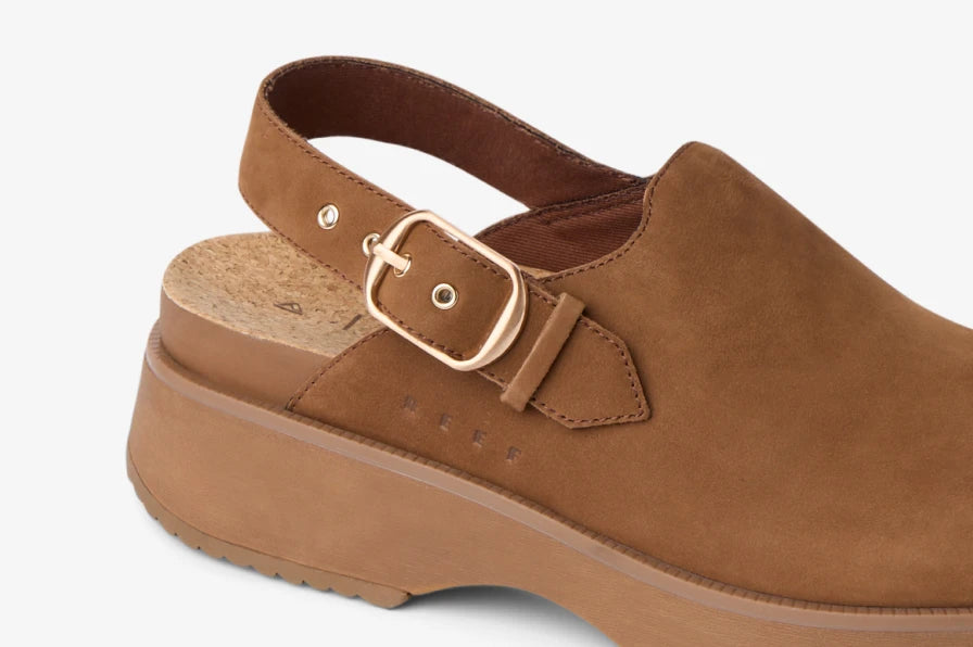 Close-up of brown suede clog facing left, showing adjustable back strap, cushioned footbed, and molded arch support.
