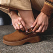 Close-up of left foot showing the adjustable backstrap and buckle on the right-facing Vista Skye Rosa clog in brown leather