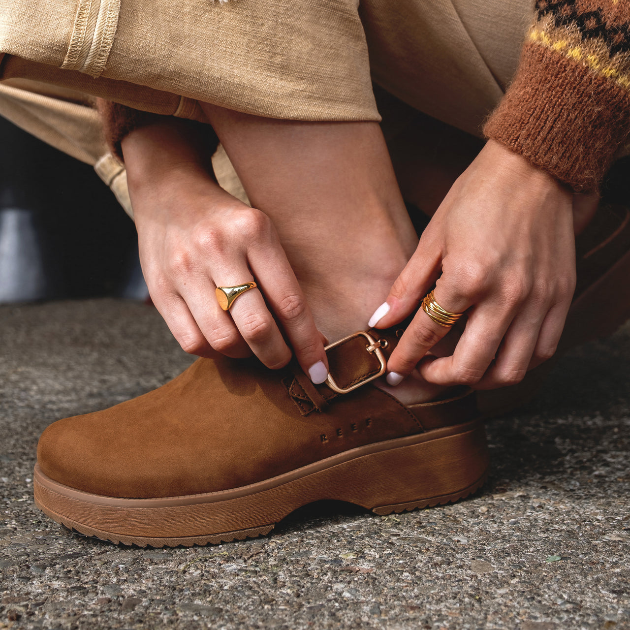 Close-up of left foot showing the adjustable backstrap and buckle on the right-facing Vista Skye Rosa clog in brown leather