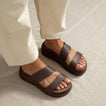 Feet wearing brown Cali Solana sandals facing forward, showcasing cushioned platform sandals for beach and travel comfort.